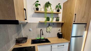 Una cocina moderna con estufa integrada, un lavaplatos, un refrigerador y armarios de madera.