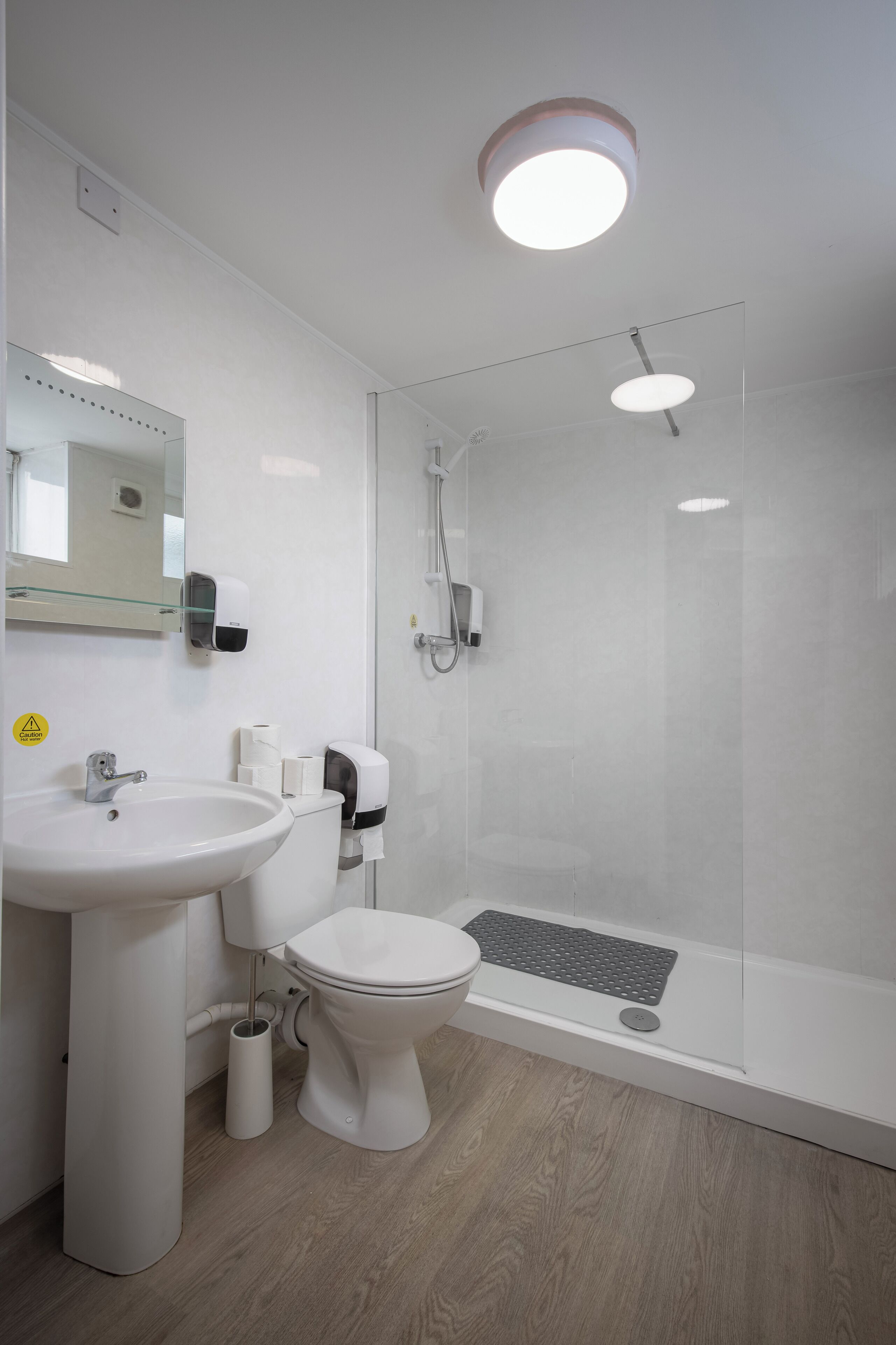 A modern bathroom with a sink, toilet, and glass-enclosed shower.