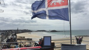 Um bar com vista para uma praia e uma bandeira.