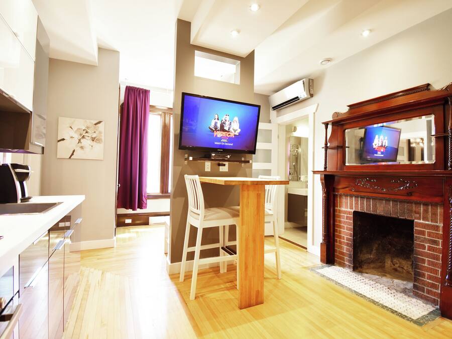 Una sala de estar moderna con televisión, chimenea, comedor y cocina.