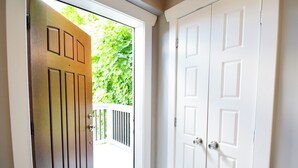 A wooden door leading to a balcony with a white railing.