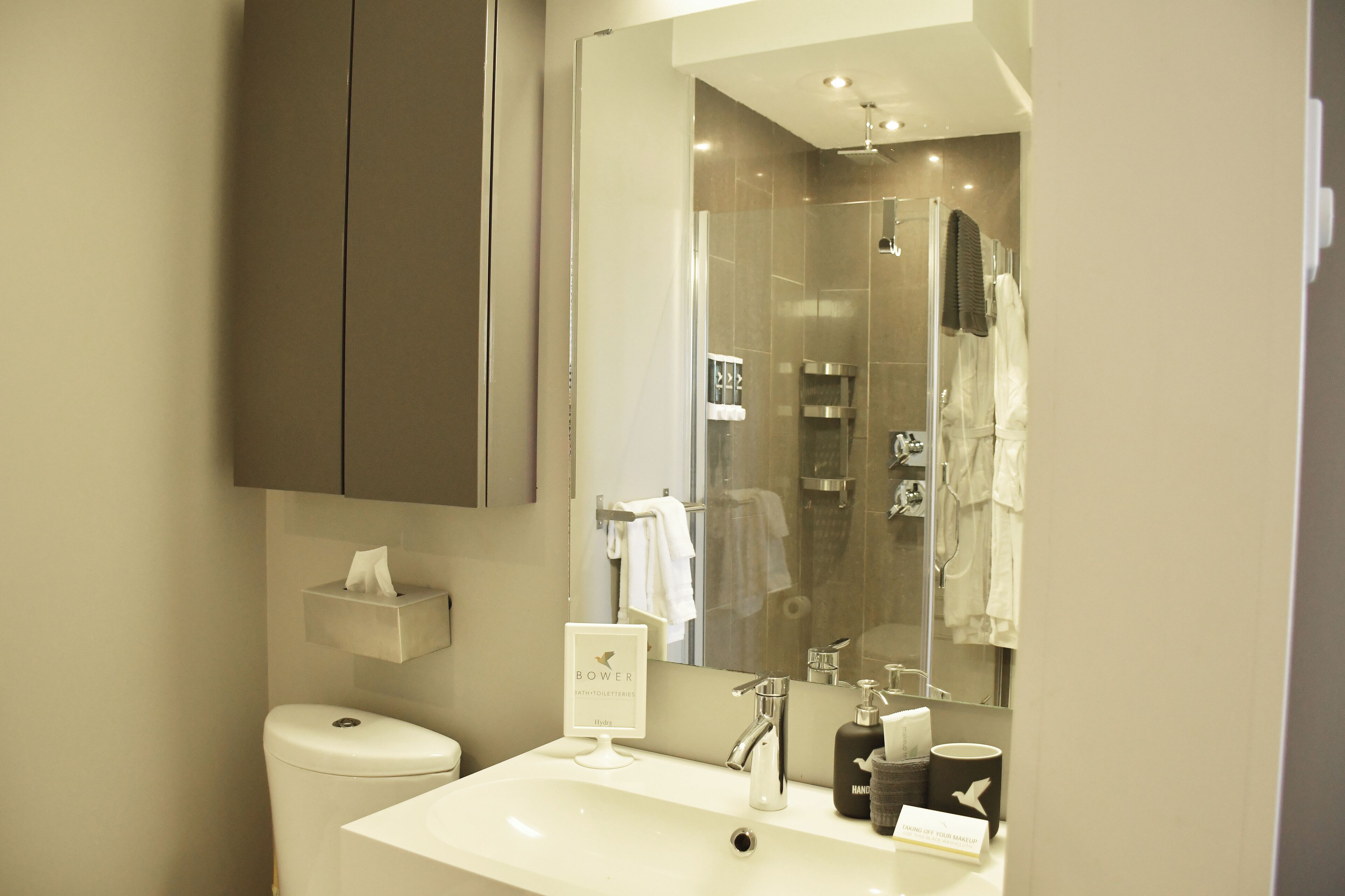 A modern bathroom with a toilet, sink, and shower area.