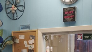 Vastaanottotiski, jossa on ilmoitustaulu, kello ja kyltti, jossa on tietoa Arkansasin piirikunnan sheriffien toiminnasta.