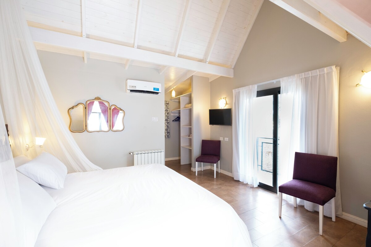 Une chambre à coucher comprenant un lit, une chaise, une armoire et une porte donnant sur une autre pièce.