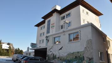 A building with a sign reading "Hotel Elite" and a mural of a mountain scene.