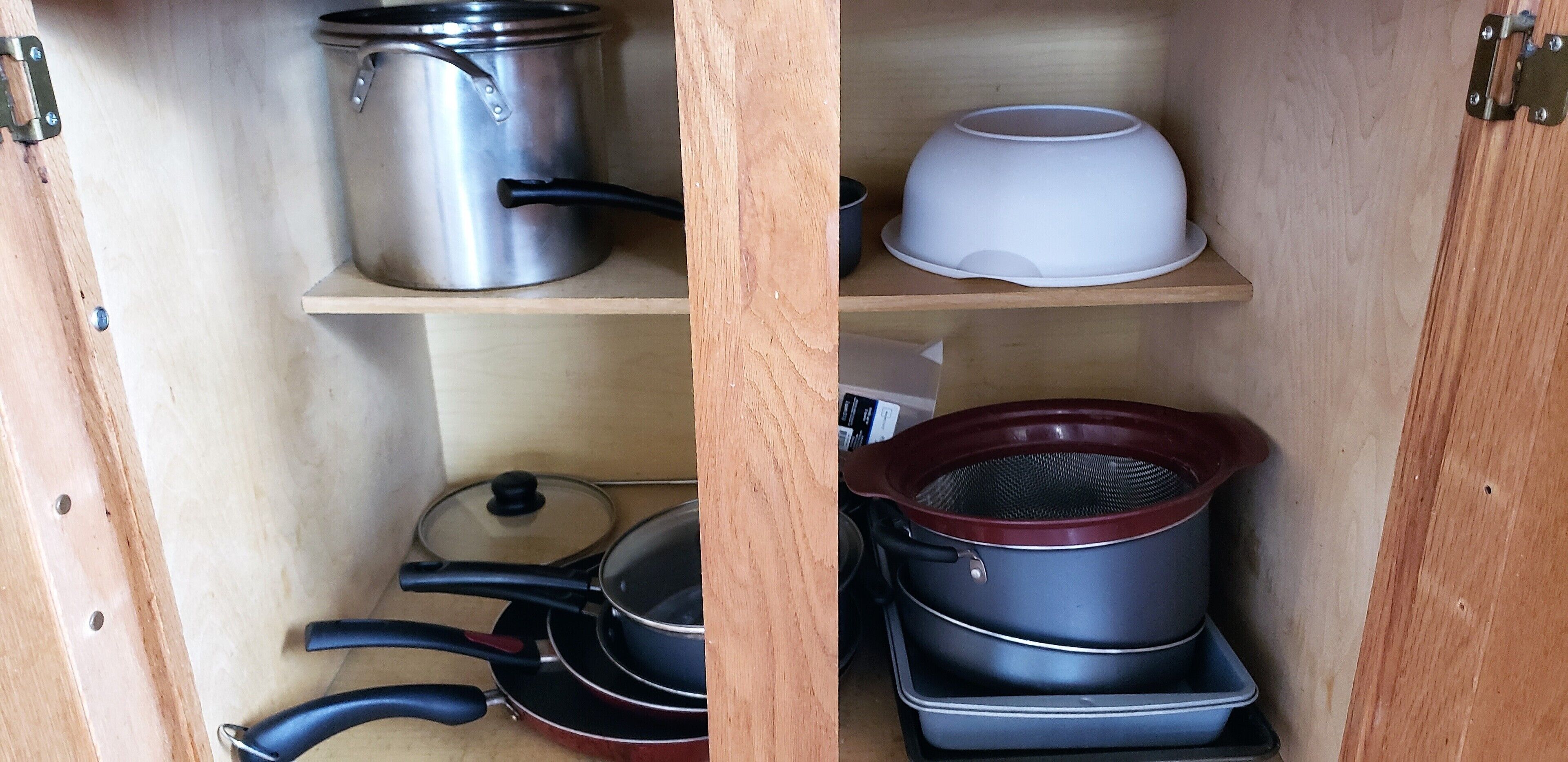 Een houten kast met planken vol keukengerei.