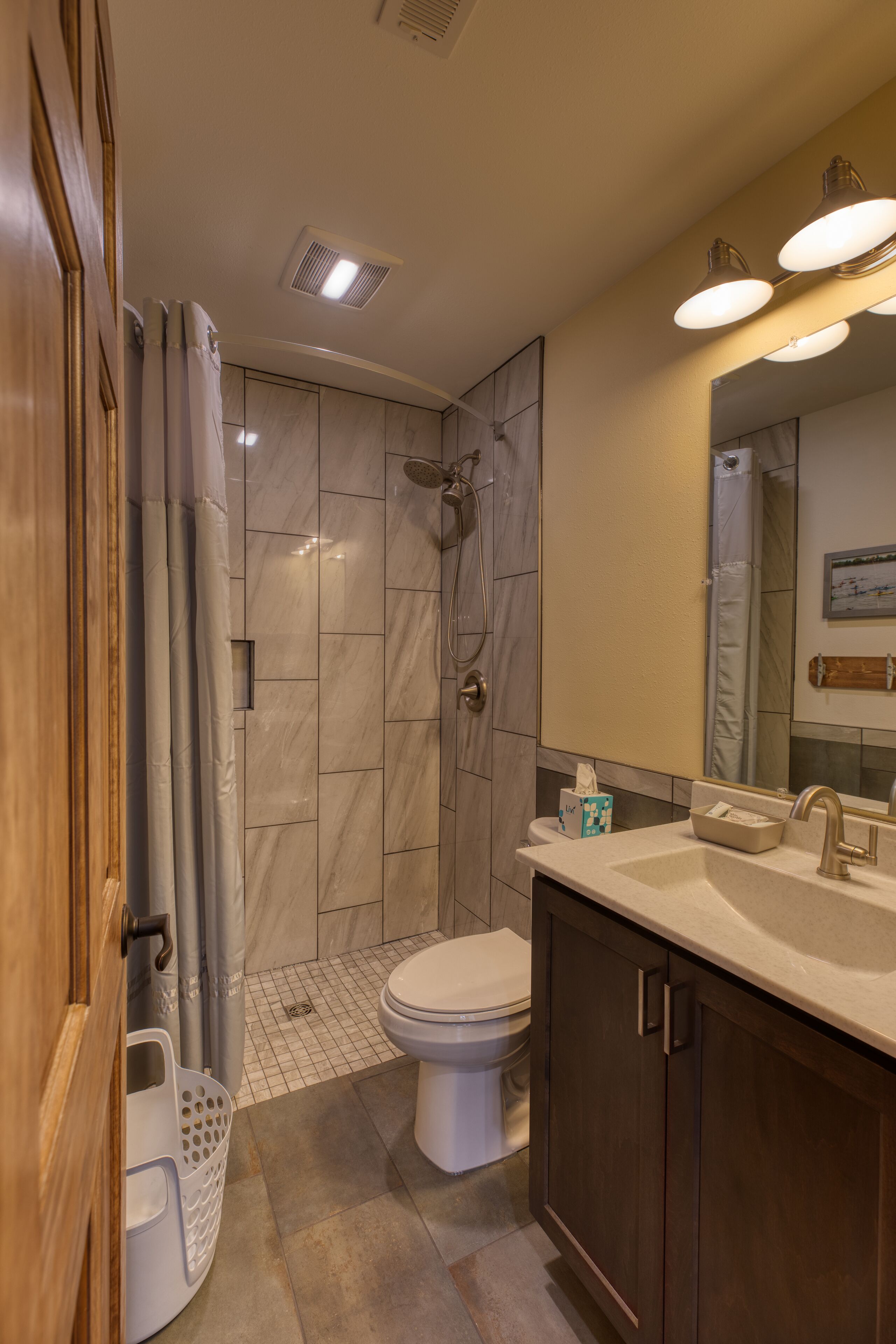 Un baño moderno con ducha, inodoro y tocador.