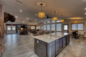 A spacious kitchen with a large island, modern pendant lights, and a ceiling fan. - Lewis and Clark Resort (Yankton)