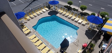 Una piscina al aire libre de temporada, sombrillas, tumbonas