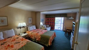 Hotellihuone, jossa on kaksi sänkyä, työpöytä, tuoli ja näkymä ulos.