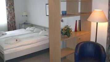 Ein Hotelzimmer mit Bett, Schreibtisch, Stuhl und Lampe.