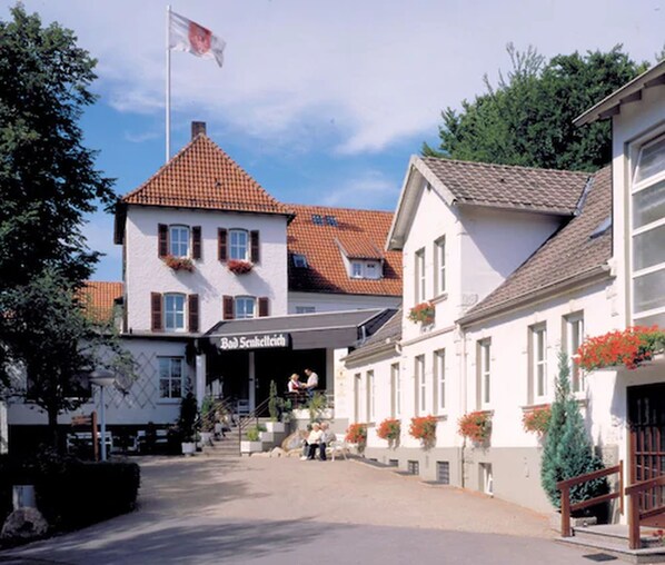 A traditional European building with a tiled roof, a flag, and a sign reading "Bob Sunkeltsch."