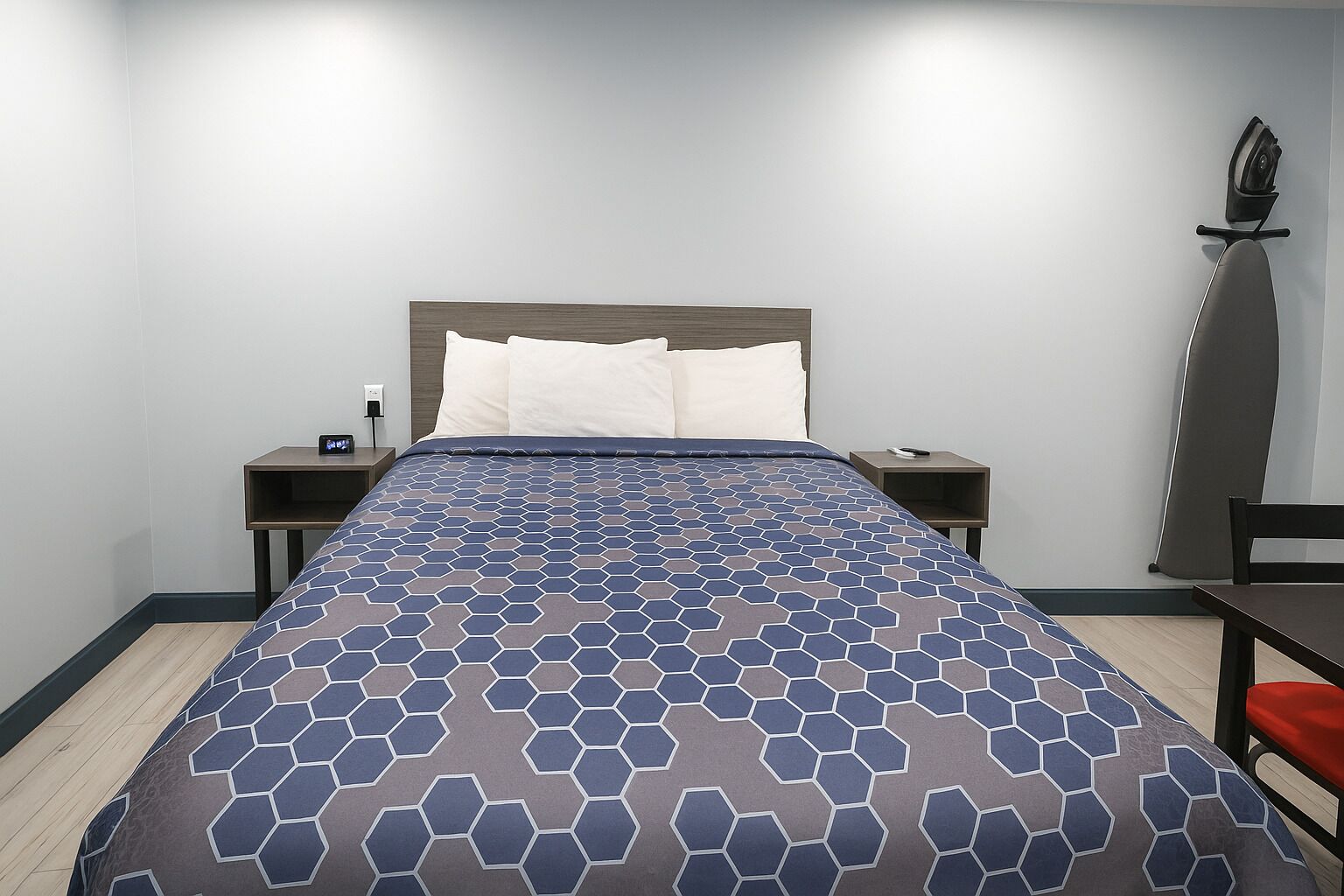 A hotel room with a bed, two bedside tables, a chair, and a desk.