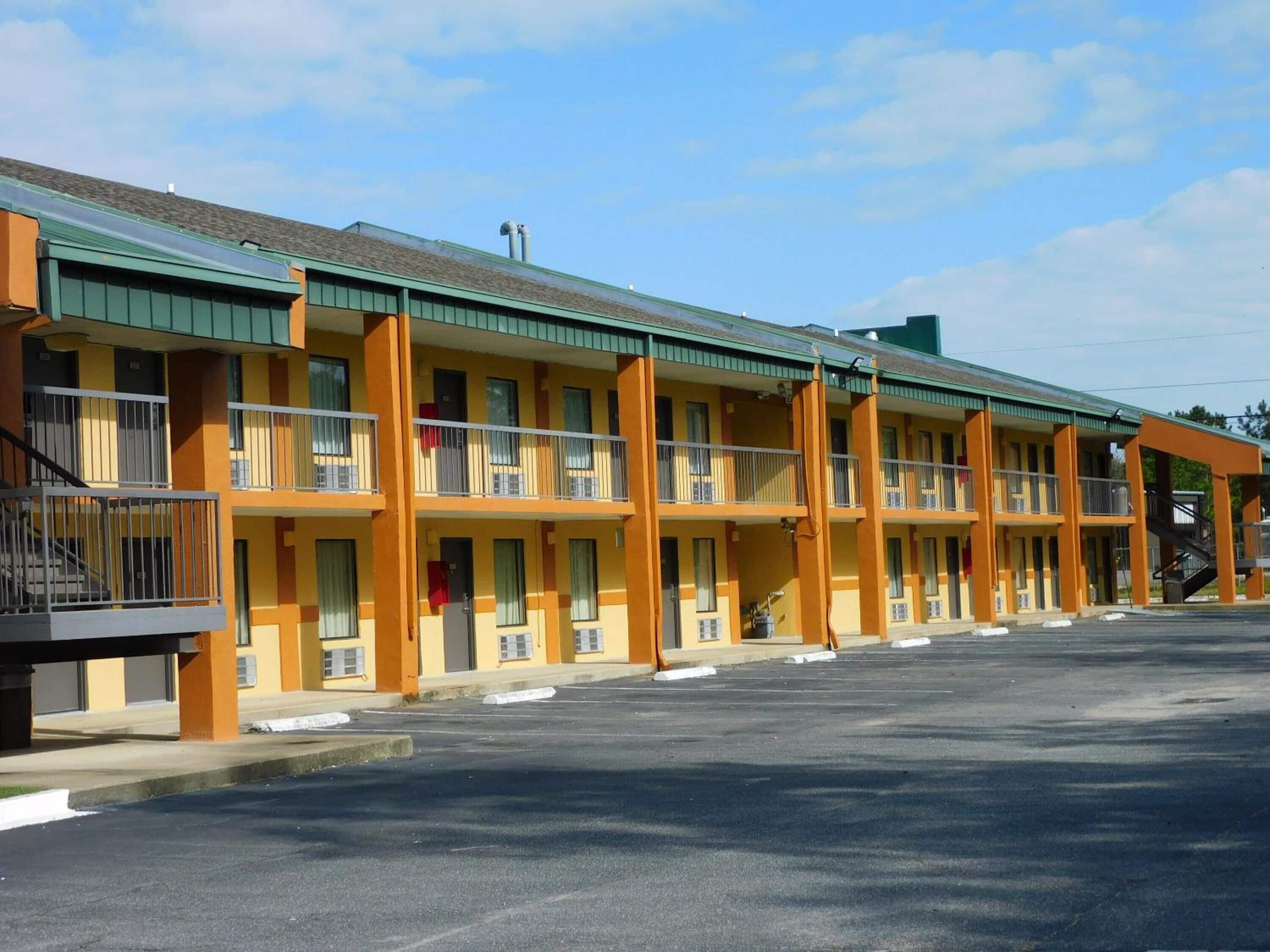 Un motel à plusieurs étages, chaque étage étant doté de balcons et d’un couloir central.