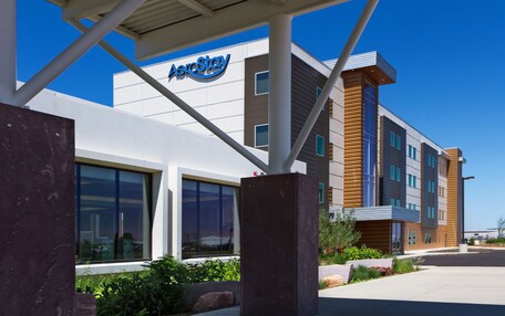 A modern building with a sign reading "AeroStay" and large windows.