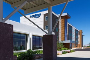 Un bâtiment moderne avec une enseigne indiquant « AeroStay » et de grandes fenêtres.