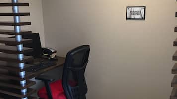 A workspace with a desk, chair, and a sign labeled "BUSINESS CENTER".