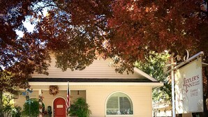 A two-story building with a red door and a signboard for 'Soodler's Inn Bed and Breakfast' established in 1912. - Fiddler's Inn (Carlsbad)