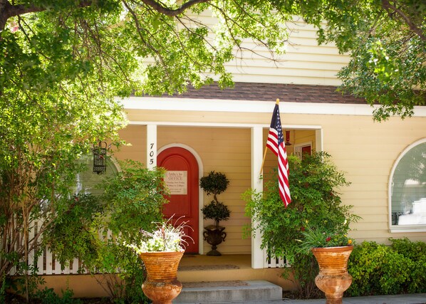 A house with a red door, an American flag, and a sign for 'Fiddler's Inn Office'. - Fiddler's Inn (Carlsbad)