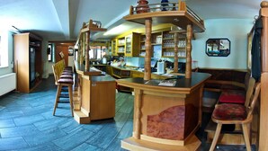 A bar area with wooden furniture, a counter, and shelves with glasses and bottles. - Landgasthof Probstei Zella (Amt Creuzburg)