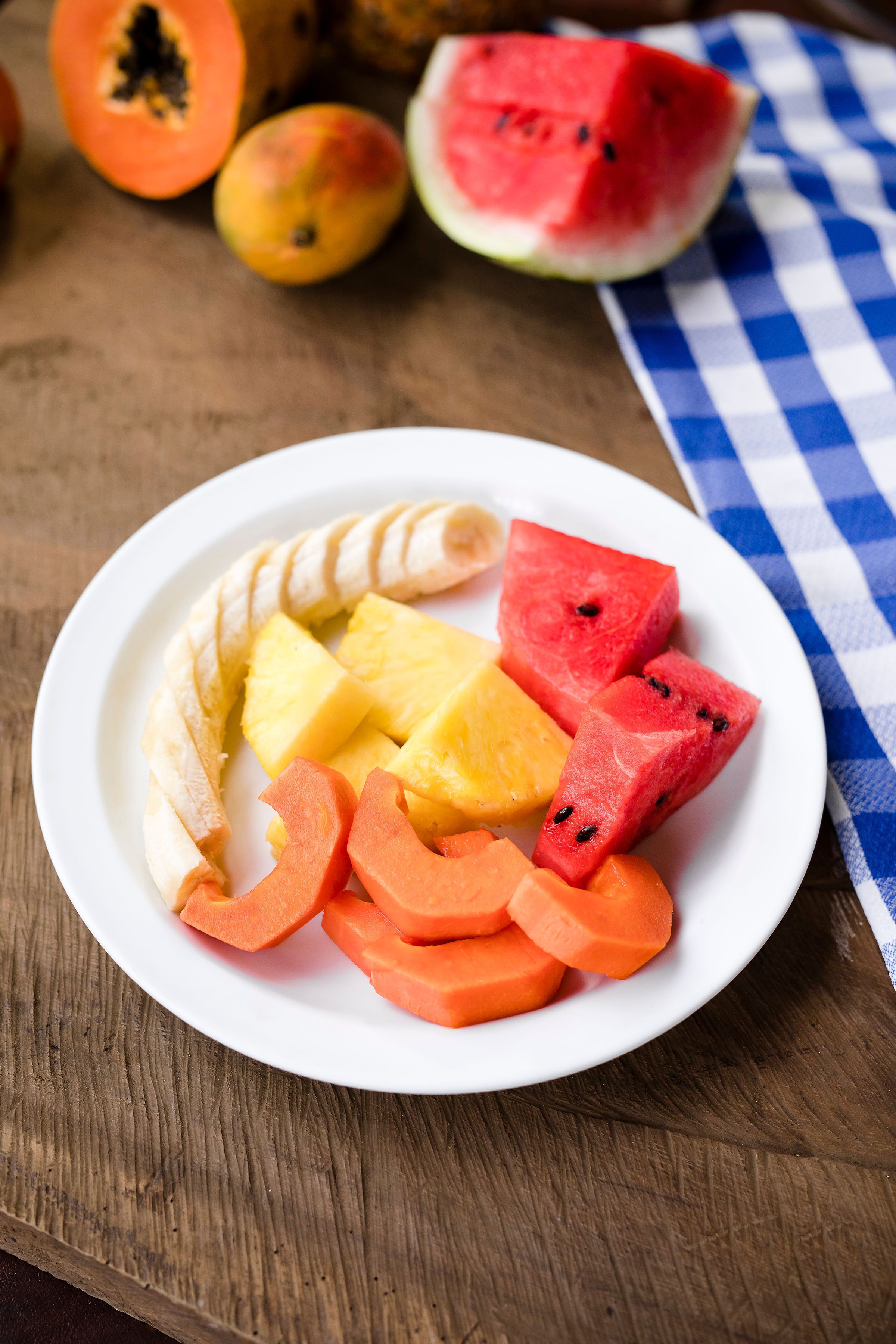 Un piatto di frutta a fette, tra cui anguria, mango, ananas e papaya.