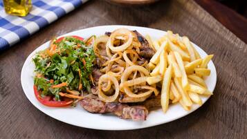 Un piatto con bistecca, patatine fritte e insalata.