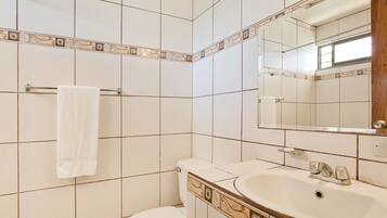A bathroom with a toilet, sink, and towel rack.