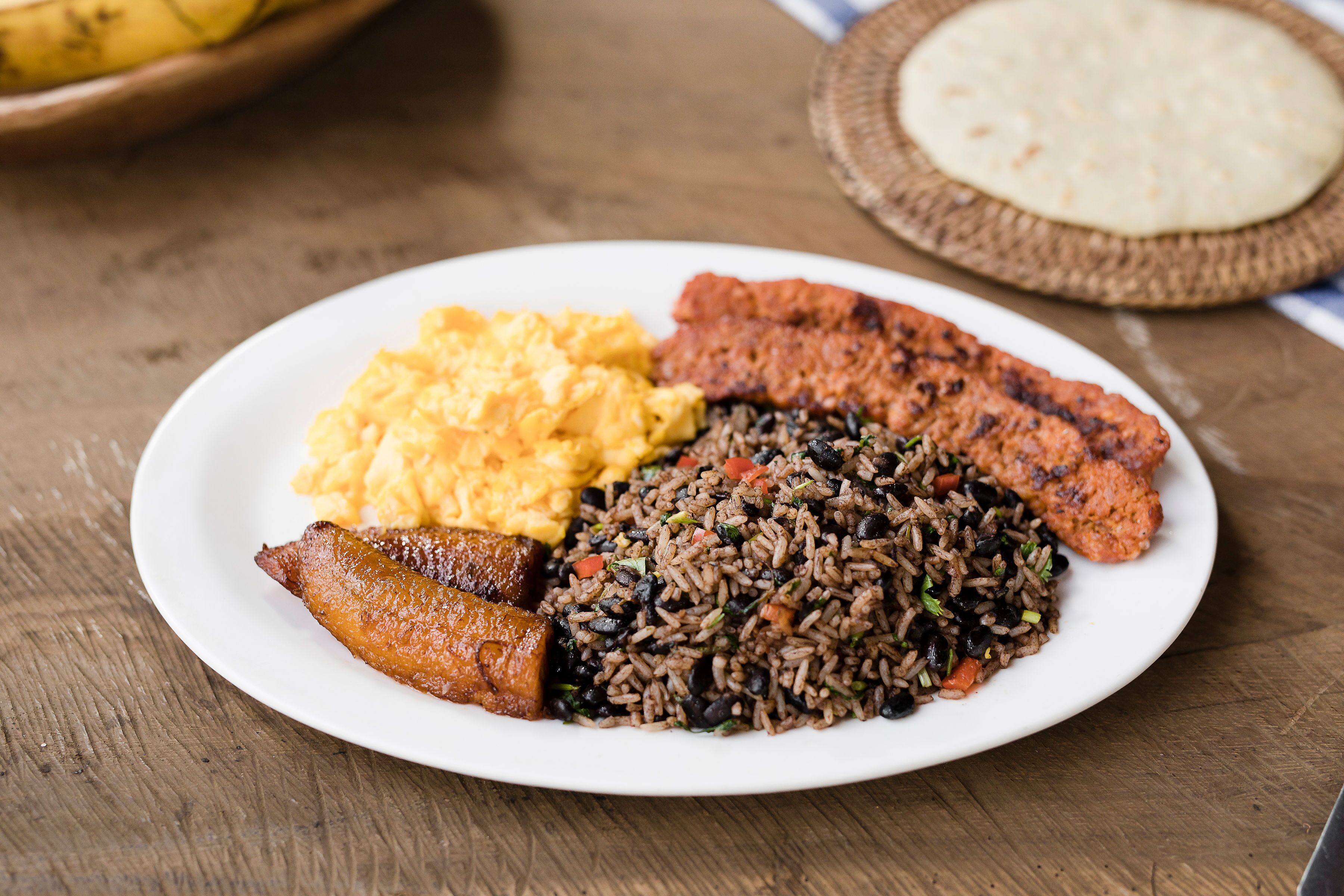 Un plato de comida con arroz, frijoles, huevos y plátanos.