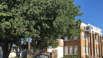 The Hunters Lodge Motel sign with a brick building in the background.