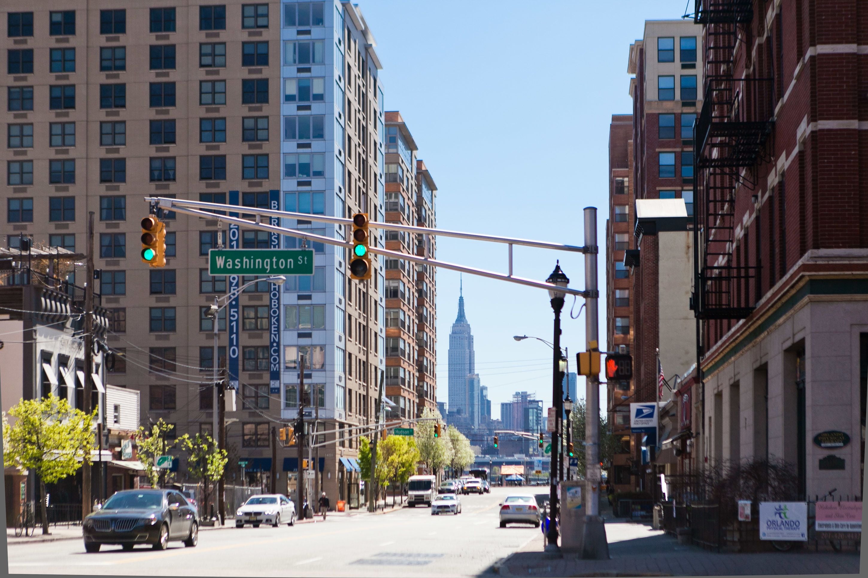 A street view with buildings, traffic lights, and cars.