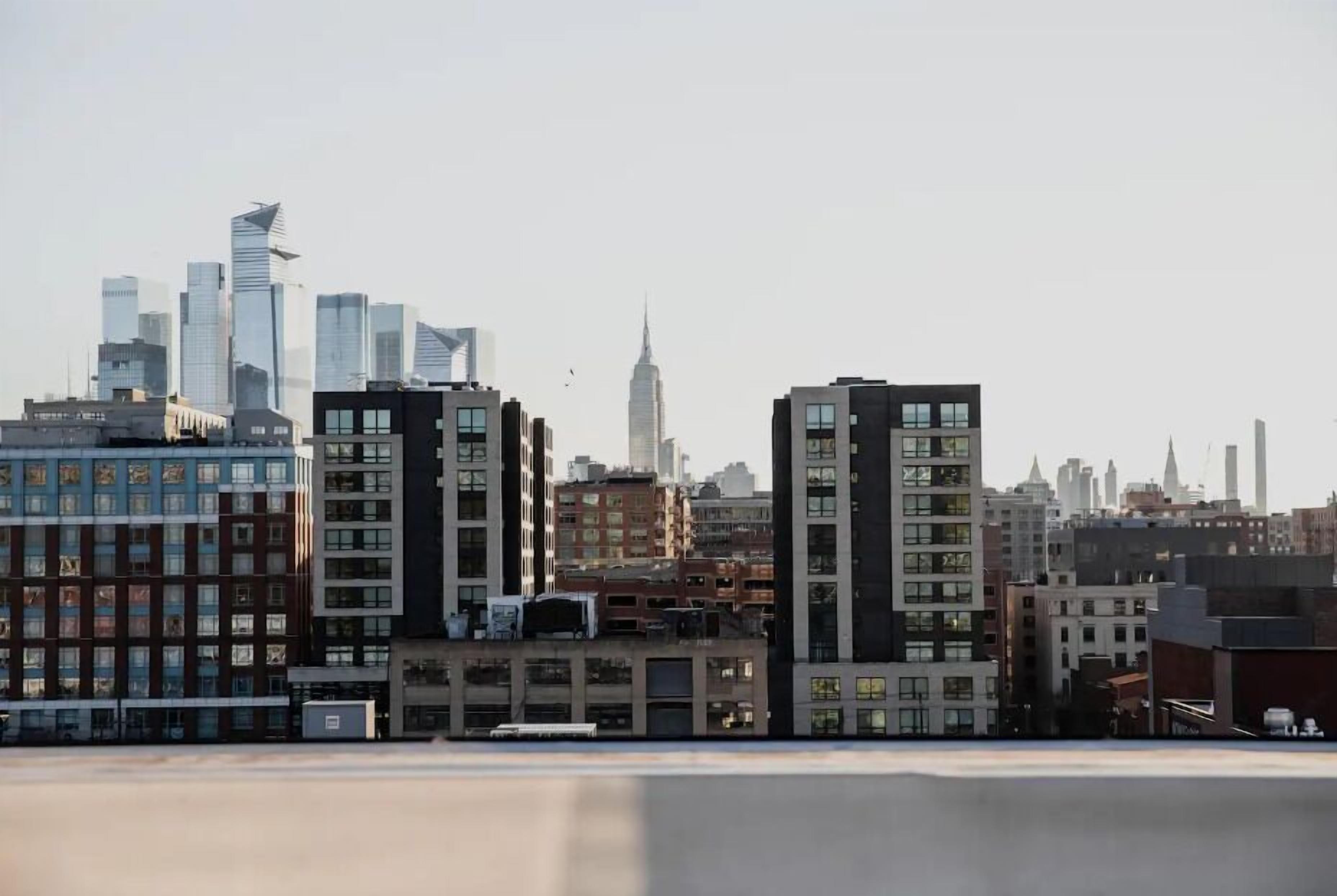 A cityscape with modern high-rise buildings, including a prominent skyscraper in the background.