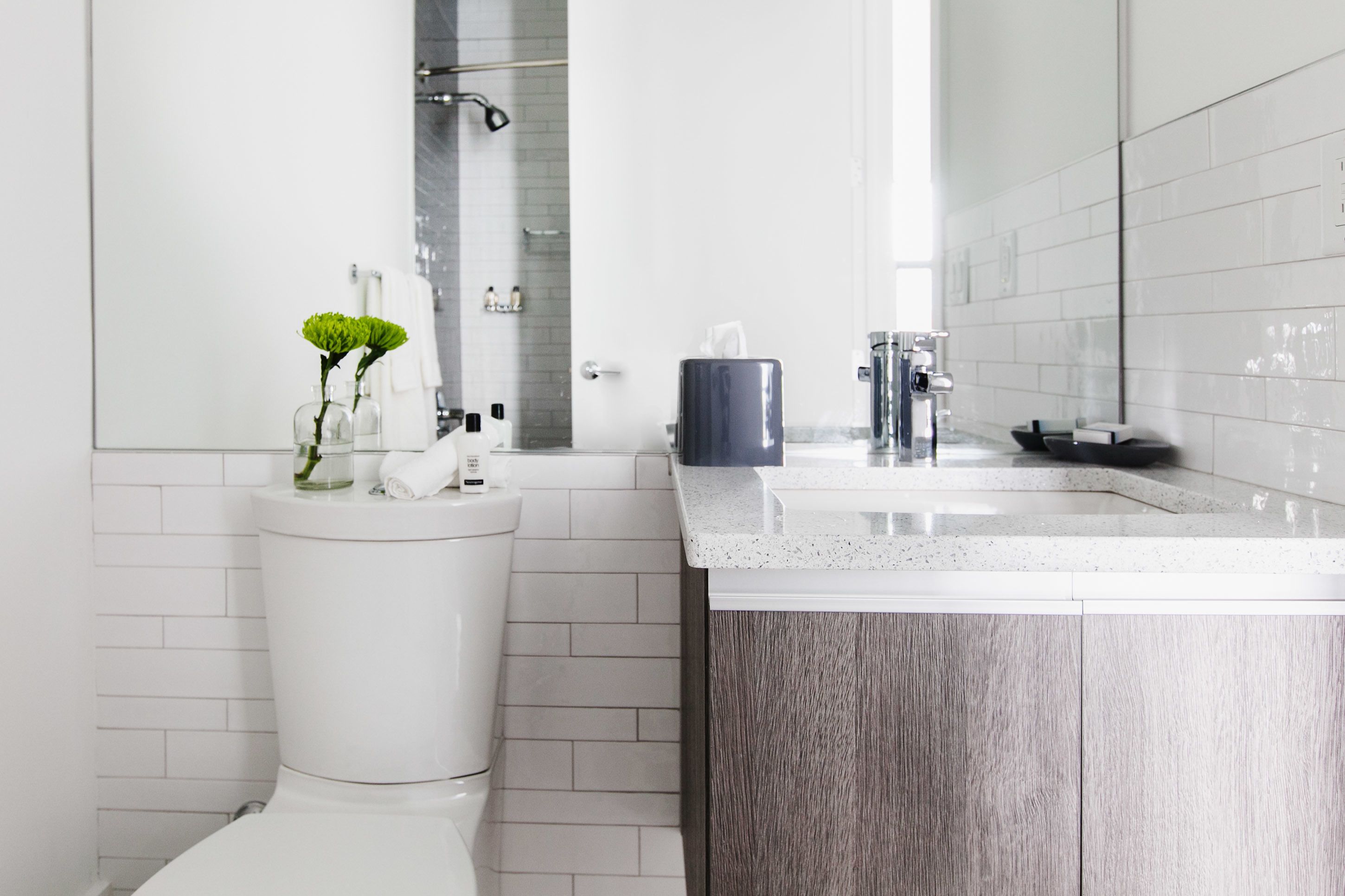 Un baño moderno con inodoro, lavamanos y espejo.