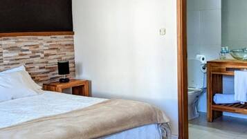A bedroom with a bed, bedside table, and an air conditioning unit.