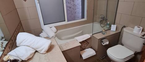 Un baño con bañera, inodoro, lavabo y ducha.