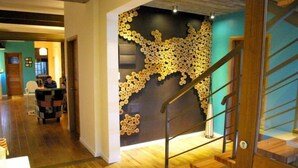A staircase with a wooden handrail and a wall decorated with circular patterns. - Nova Posada (Colonia del Sacramento)