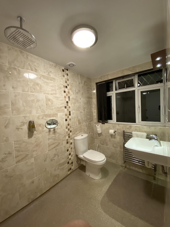 A bathroom with a toilet, sink, and shower. - Clifton House Brighton (Hove)