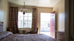A bedroom with a bed, a chair, a table, and a wardrobe. - Boron Motel (Boron)