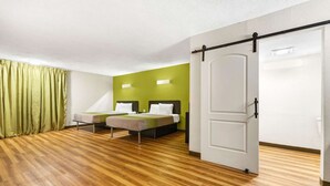 A room with two beds, a sliding door, and a green wall. - Motel 6 Indianapolis, IN (Indianapolis)