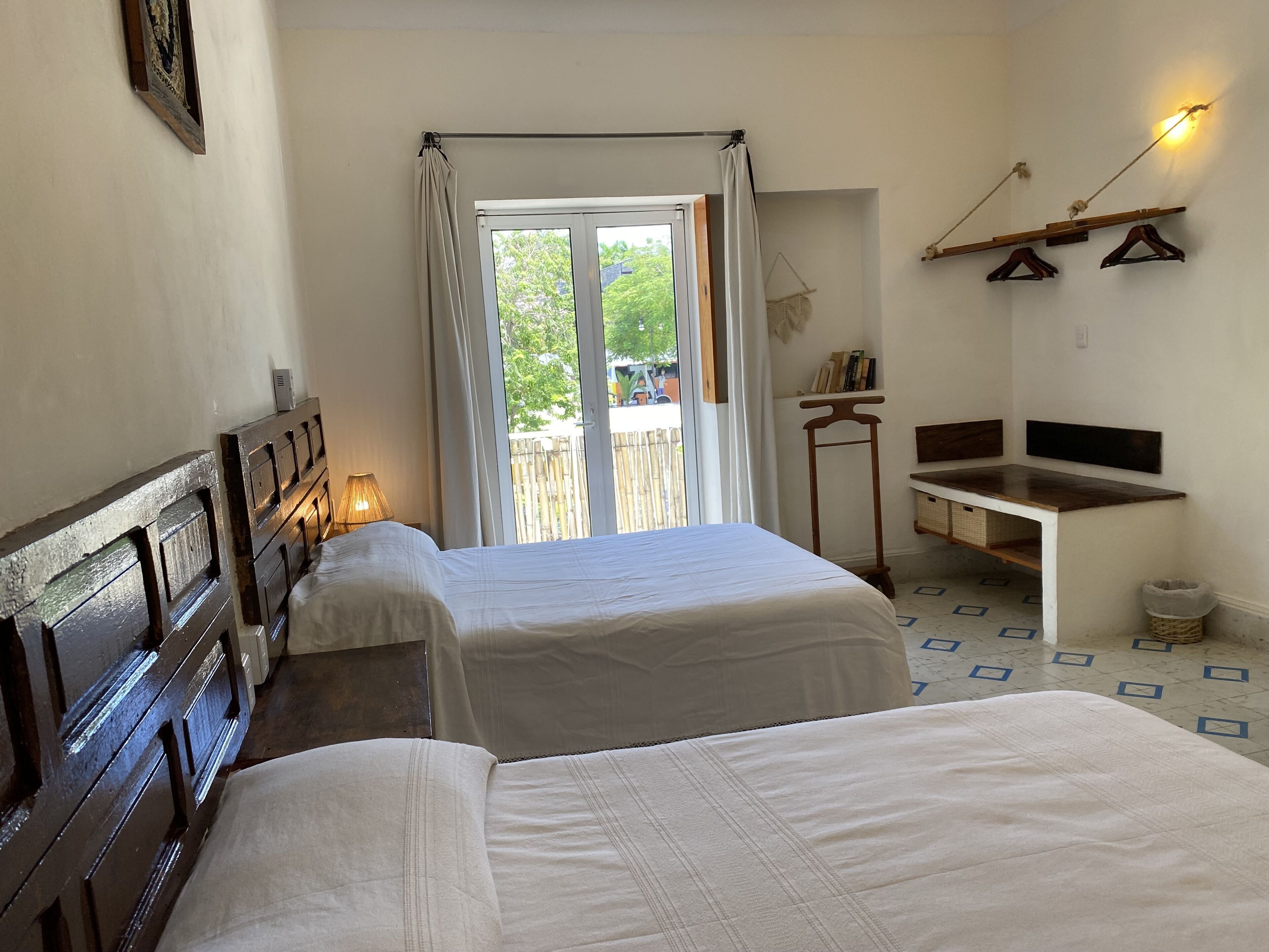 Una habitación con dos camas, un escritorio y vistas a zonas verdes.