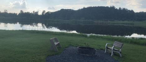 A gravel area with two benches and a fire pit.