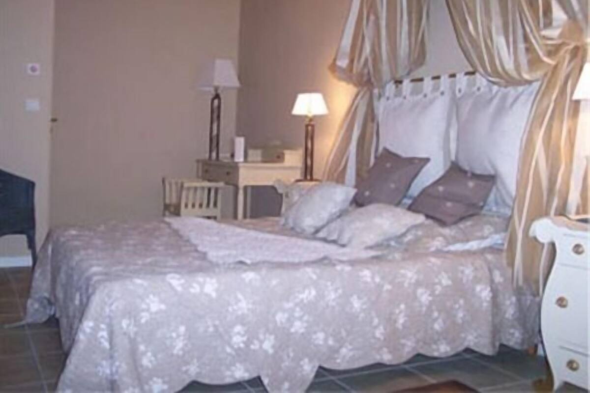 A bedroom with a bed, bedside tables, a dresser, and a lamp.