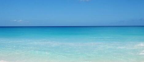 A beach with clear turquoise water and a white sandy shore.