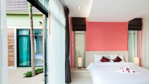 A modern hotel room with a large bed, a view of the outside, and a balcony with a palm tree. - Jinda Resort (Sa Khu)