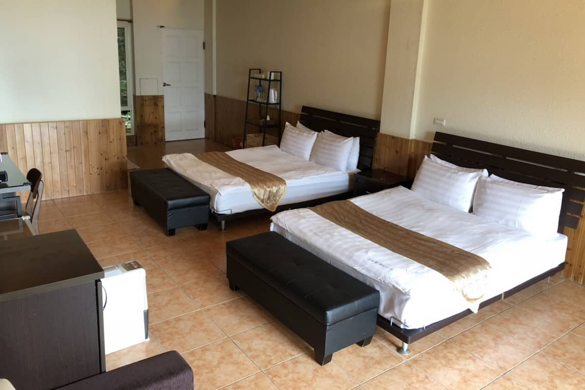 Ein Hotelzimmer mit zwei Betten, einem Schreibtisch und einem Stuhl.
