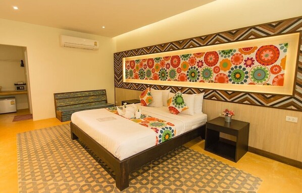 A modern bedroom with a bed, a nightstand, a wall-mounted air conditioner, and a patterned rug.