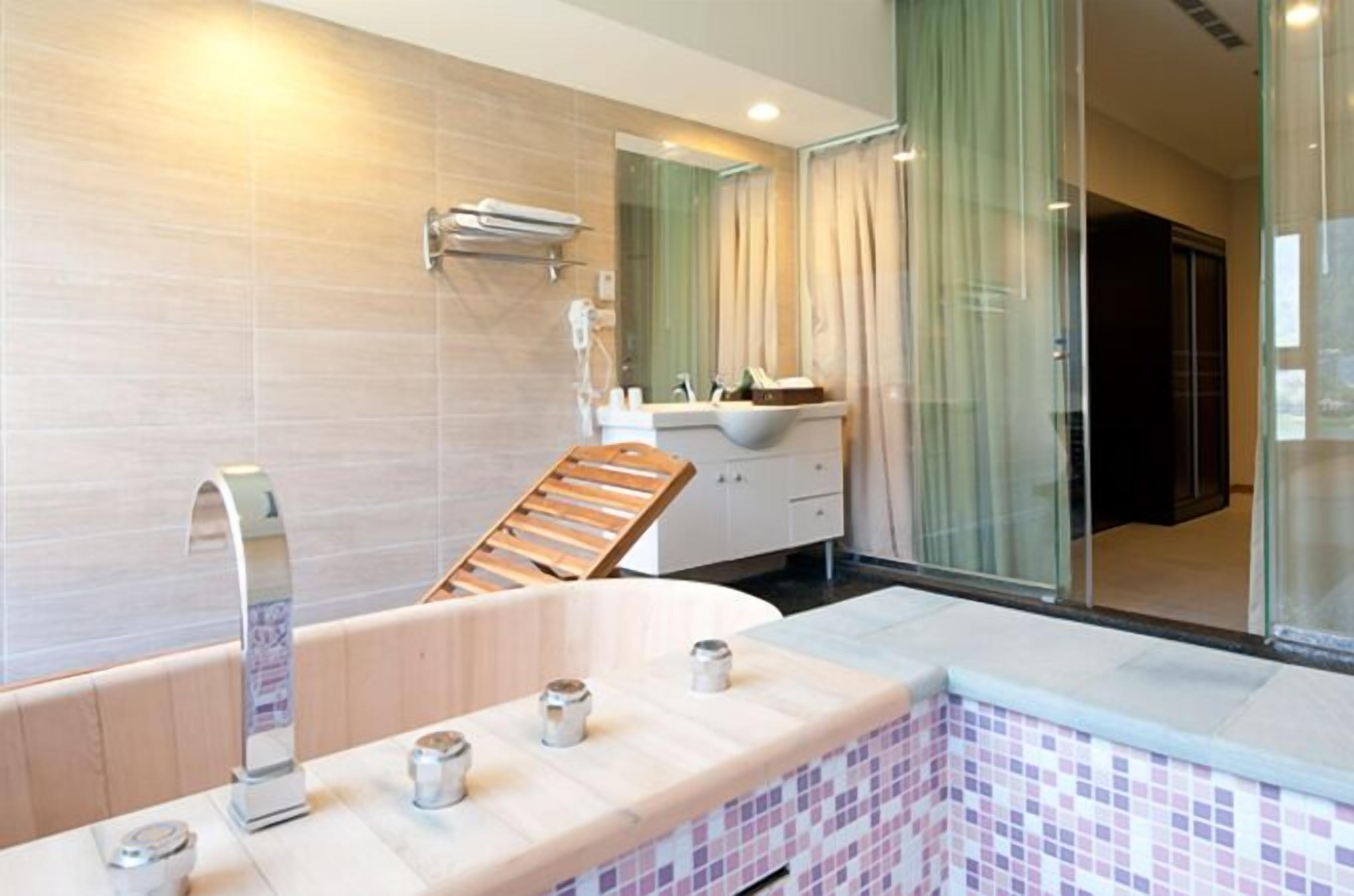 Une salle de bain moderne avec une baignoire sur pieds, un meuble-lavabo et un grand miroir.