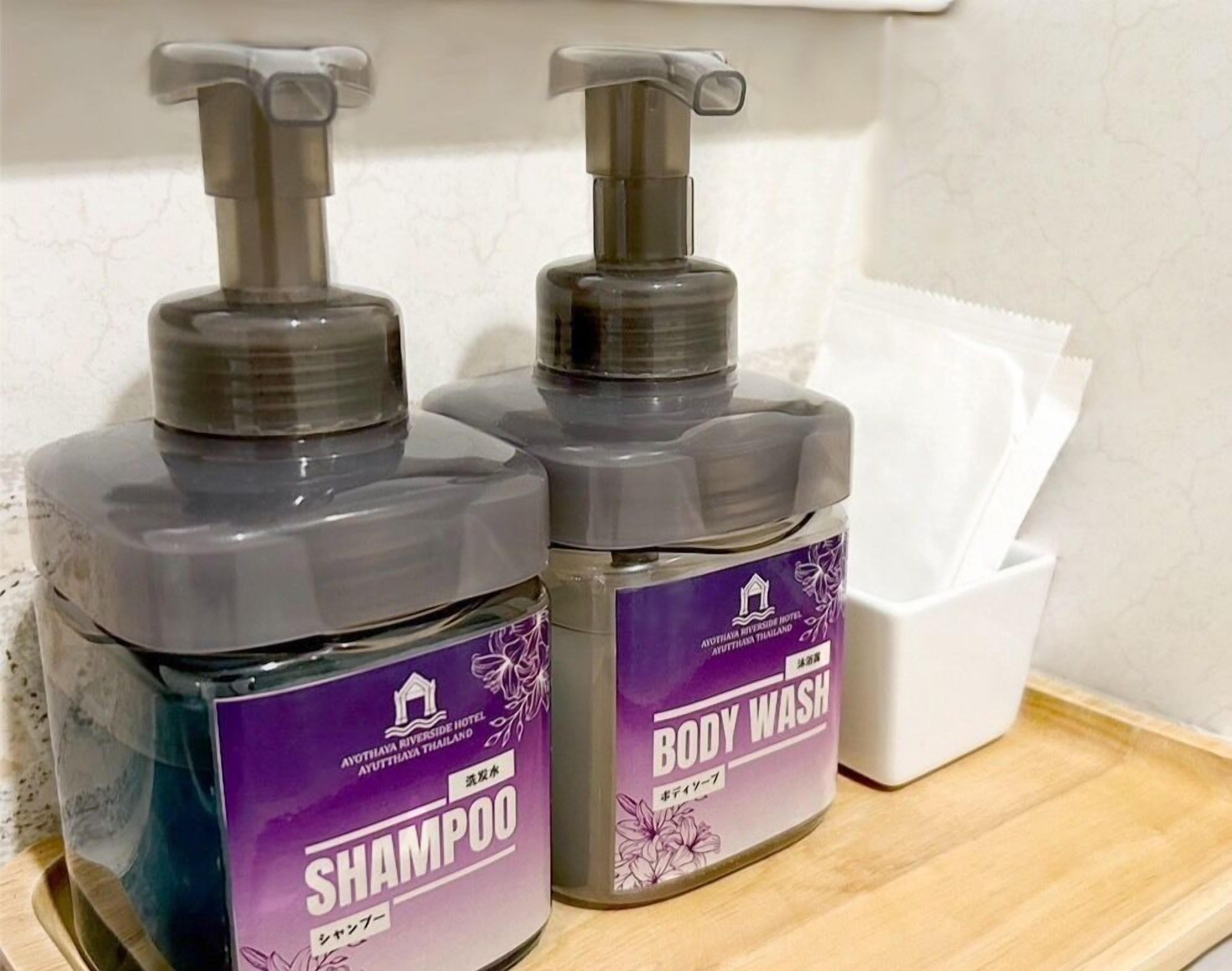 Dos botellas de champú y gel de baño sobre una bandeja de madera.