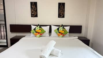 Ein Hotelzimmer mit einem Bett, zwei Wanddekorationen und zwei Kissen mit Obstmotiv.