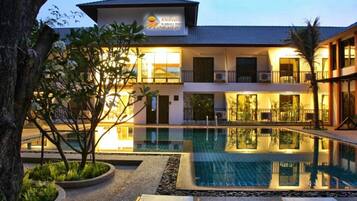 Una piscina al aire libre, sillones reclinables de piscina