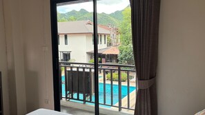 Ein Zimmer mit Blick auf ein Schwimmbad und ein Gebäude mit einem Ziegeldach.
